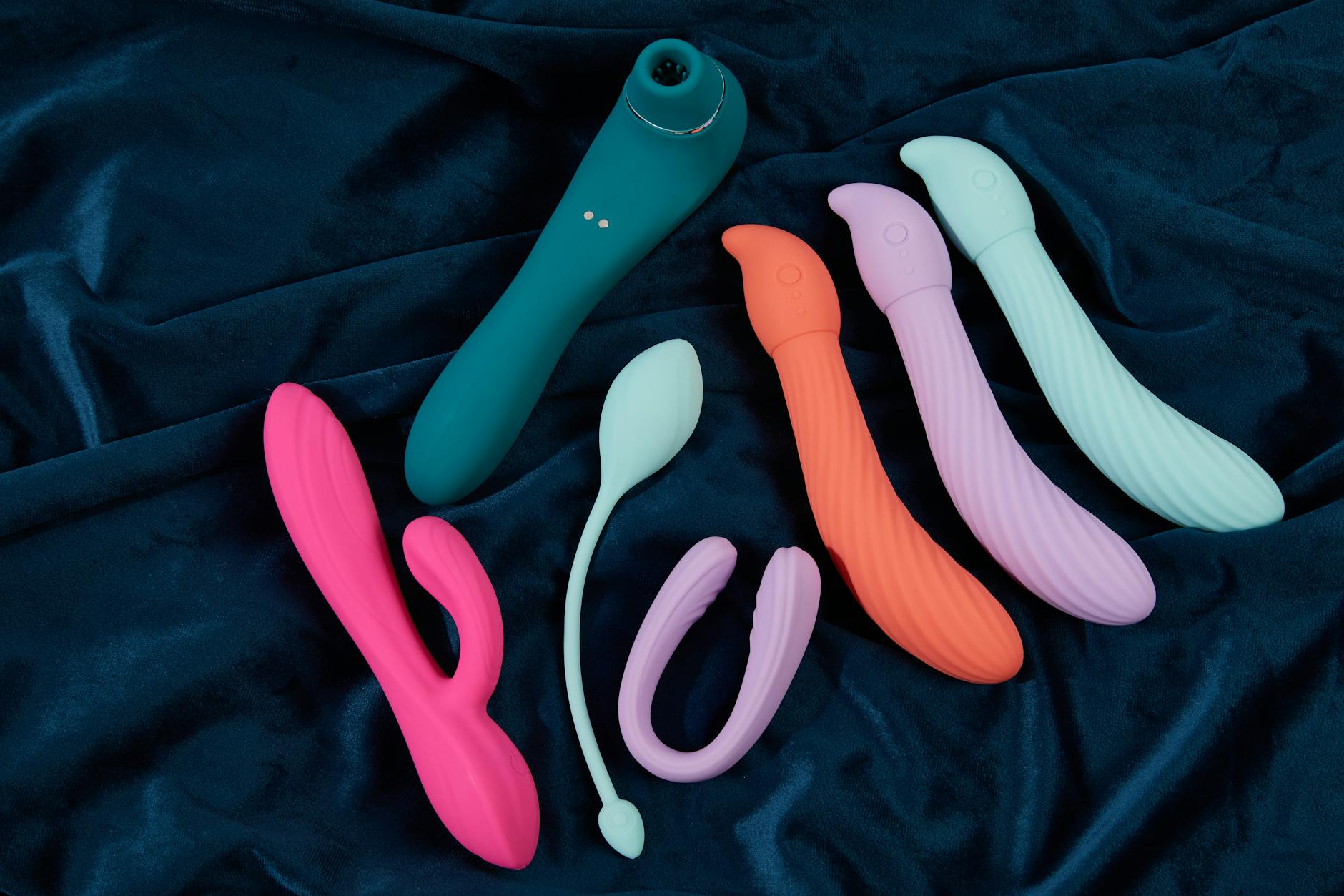 A young couple standing together indoors, holding a blue vibrator, symbolizing modern intimacy.