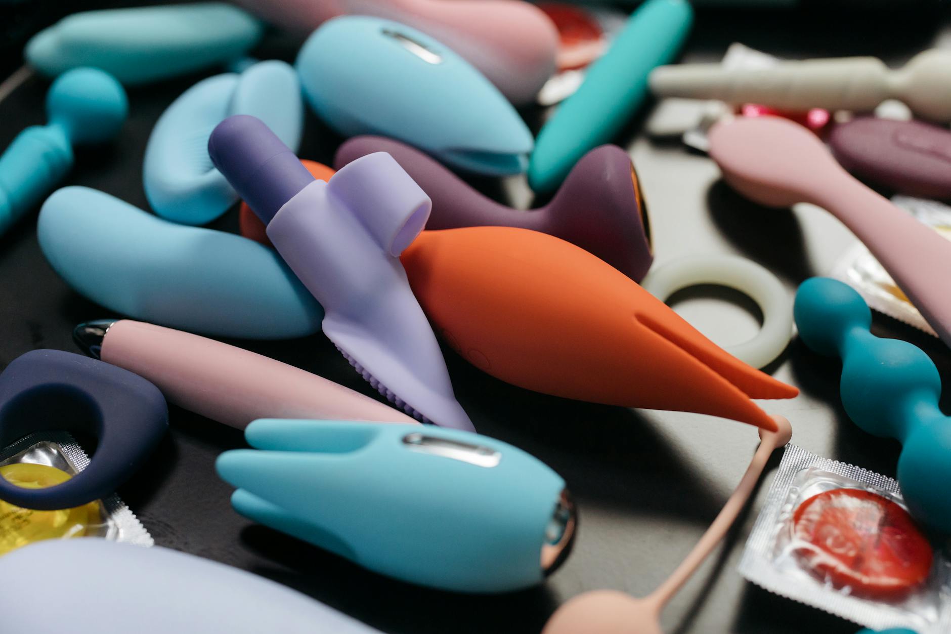 Woman holding a pink vibrator with art books nearby, representing intimacy and personal wellness during medication use