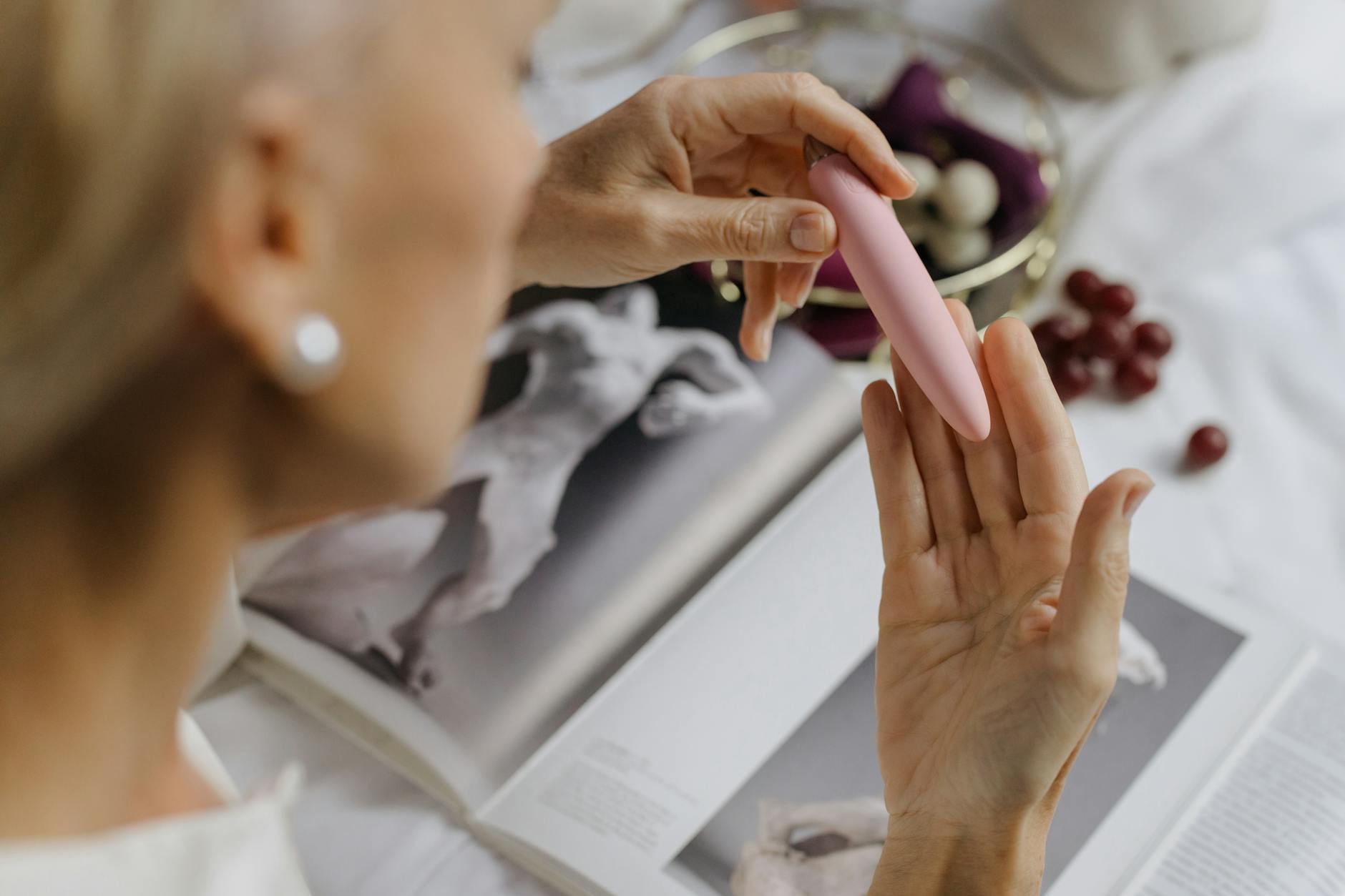 Woman holding two colorful vibrators, representing the range of sensation available with quality clitoral vibrators.
