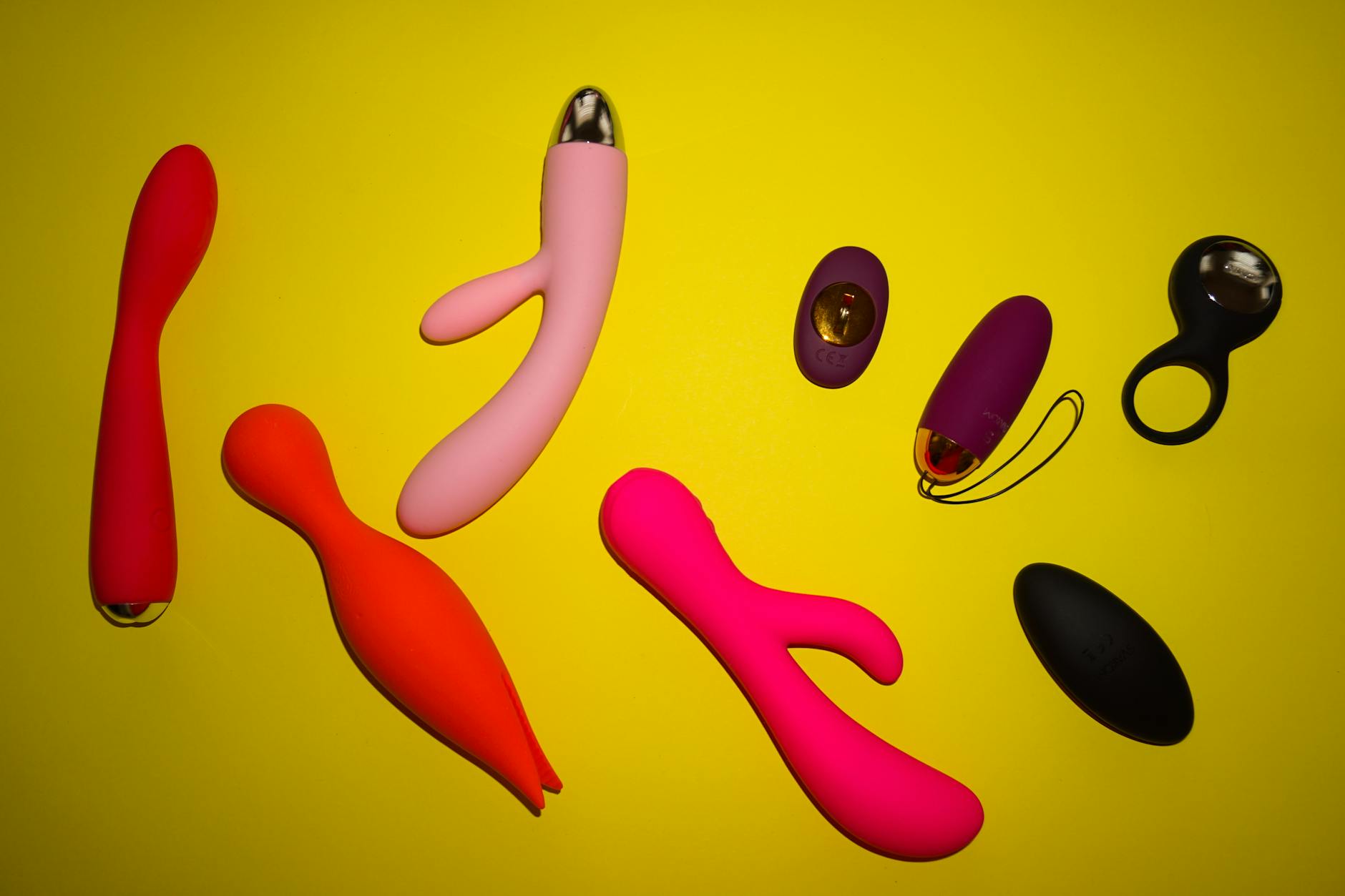 A silicone vibrator held in hand against a solid purple background, representing mindful self-pleasure